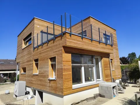 Glasgeländer Pure ohne Handlauf auf der Dachterrasse eines Hauses mit Holzfassade